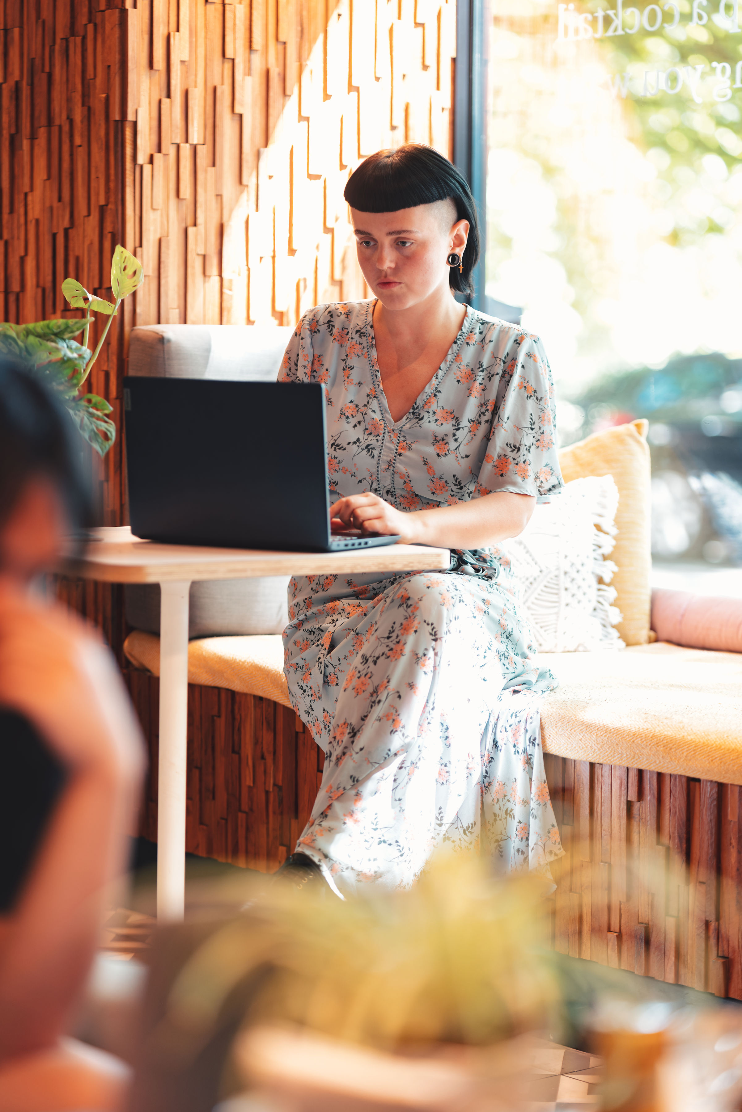 Business owner working at their laptop in a café - the kind of clients I work with