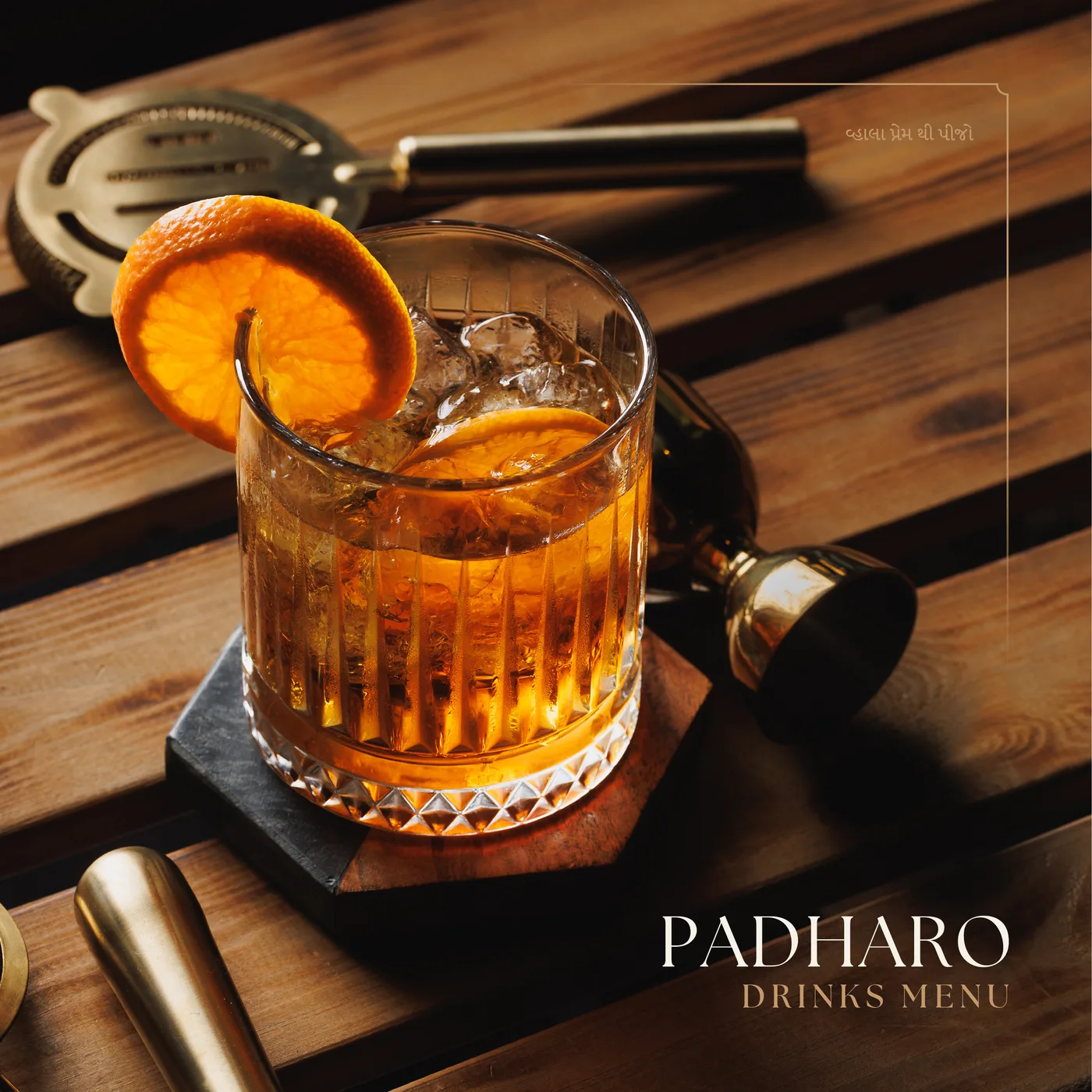 Padharo drinks menu cover: an old fashioned with an orange twist on a wooden bar top