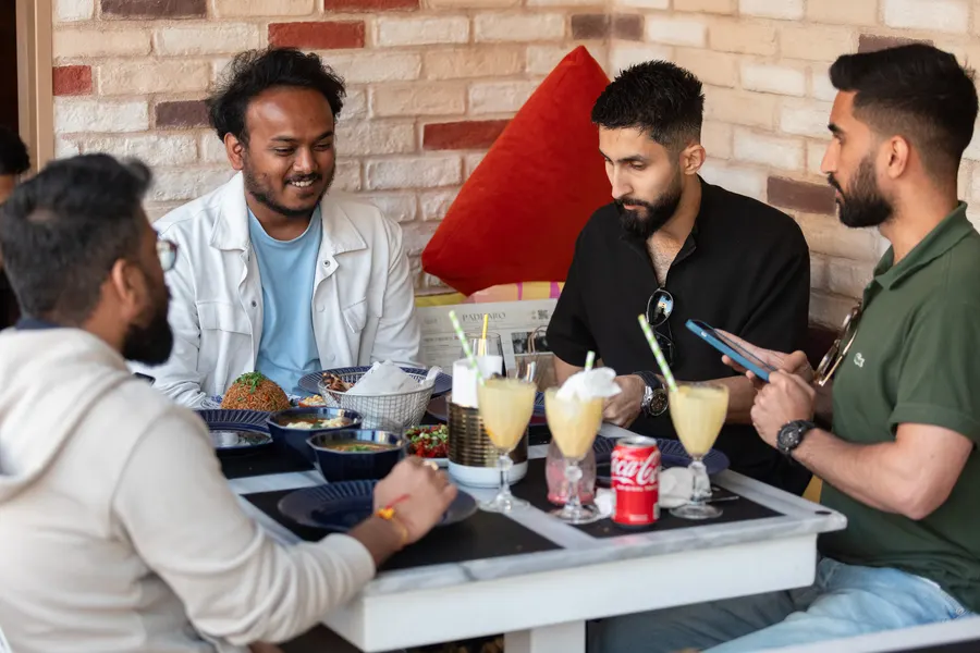 Four friends over drinks at a window table